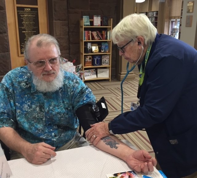 Sister Ellen Martin checks Rei Battcher’s blood pressure at one of the library’s free screenings